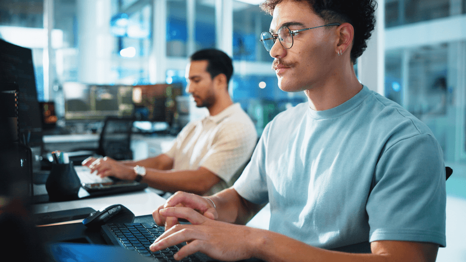 Programmers producing code on computers