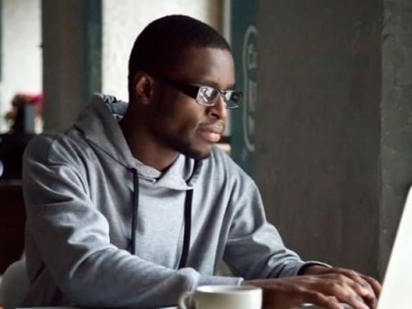 Man wearing glasses working on a laptop