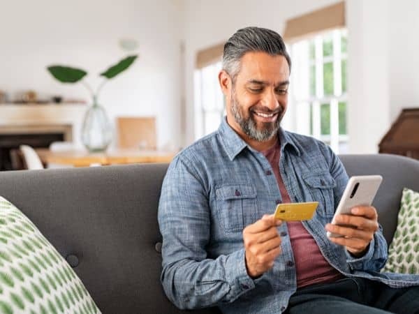 man holding a credit card and his mobile phone