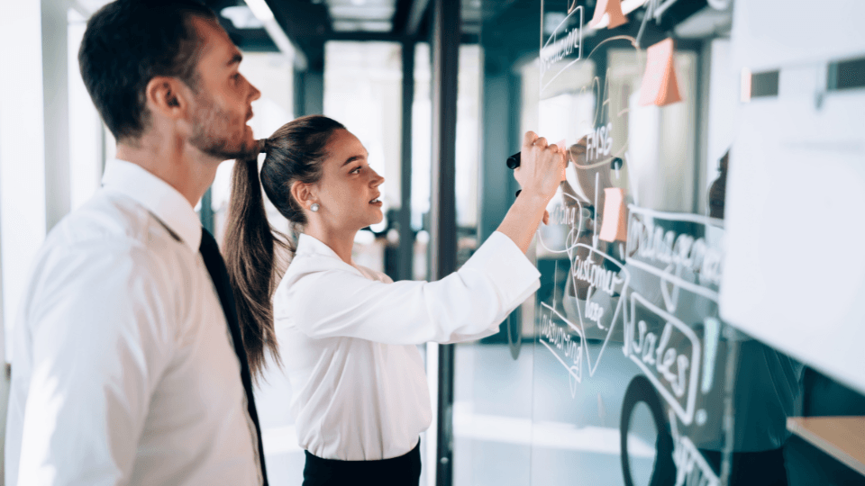 a man and woman working on business processes