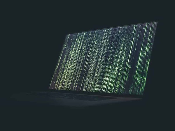 laptop screen filled with green binary code