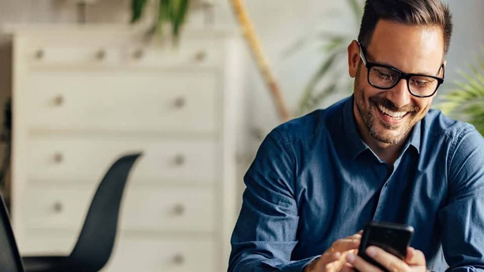 smiling man looking at mobile phone