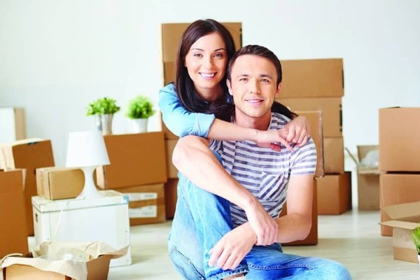 young couple in new home surrounded by packaging boxes